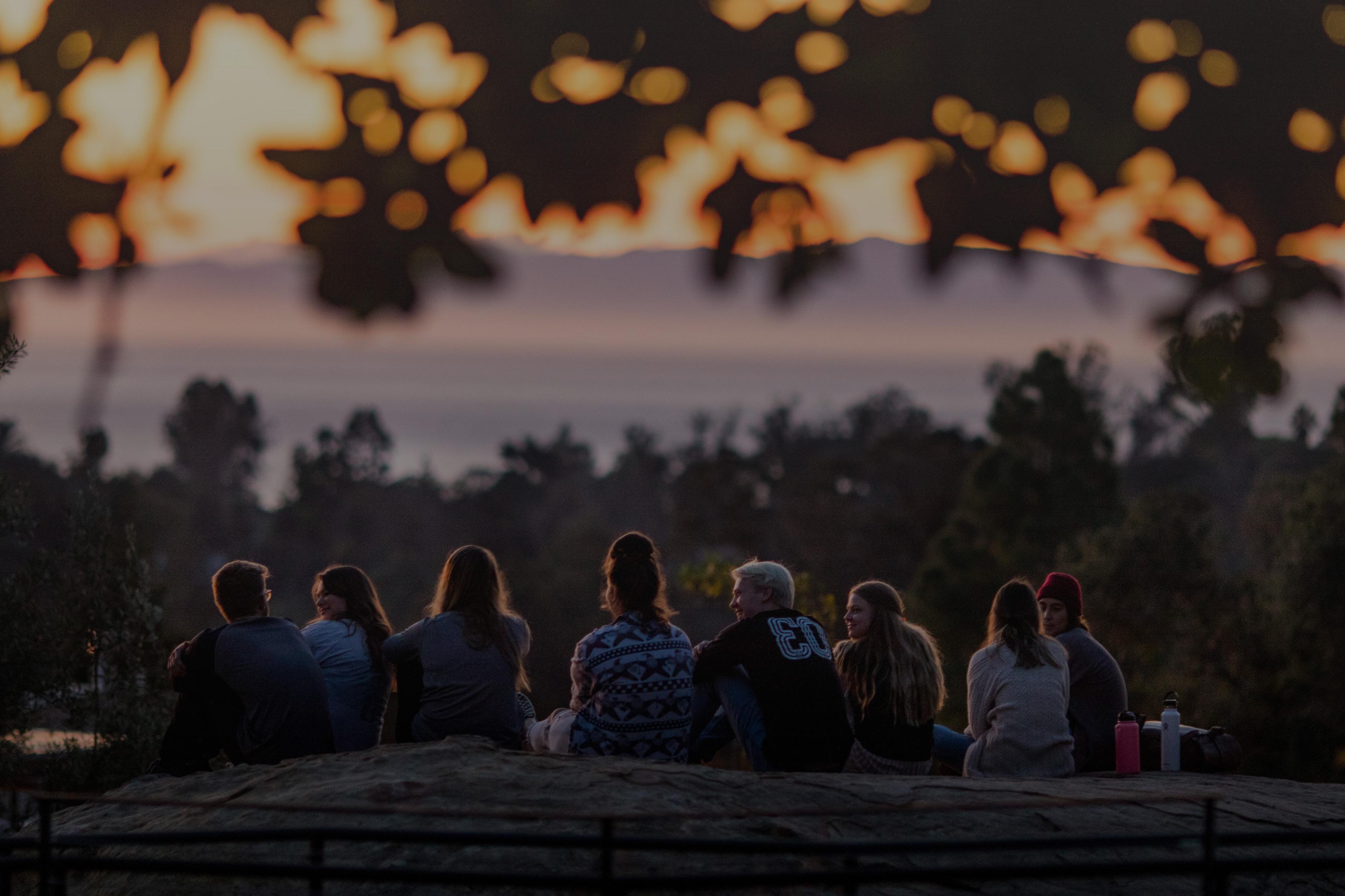 students sitting on rock looking out at view